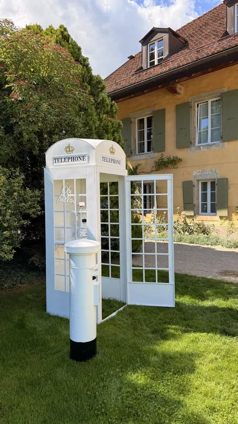 Cabine téléphonique blanche COSAM, livre d'or vidéo, installée pour un mariage à la Porte des Iris